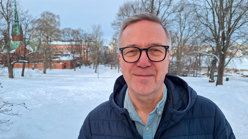 a man smiling and looking at camera outside in snowy view