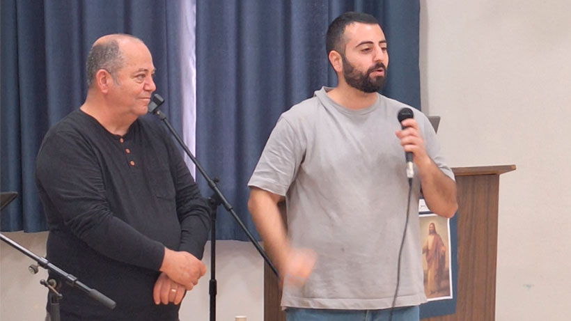 Two man standing and speaking.