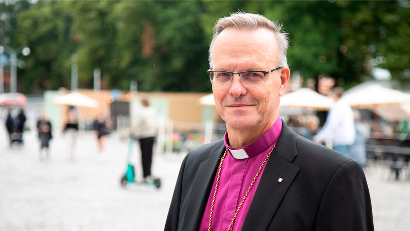 A priest looking at camera and smiling.