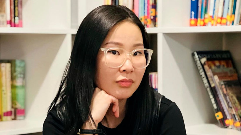 A mongolian woman looking at camera in library.