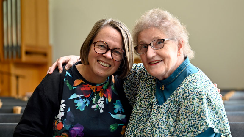 Two women hugging each other and smiling.
