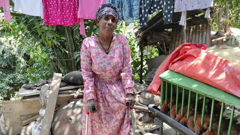 An african woman standing in her yard.